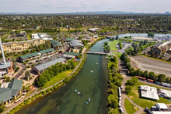 15 Haziran 2025, Bend, Oregon, ABD. İnsanlar, Deschutes Nehri 'nin Eski Değirmen Bölgesi' nden akan bu tembel öğleden sonranın tadını çıkarıyorlar. Drone görünümü.