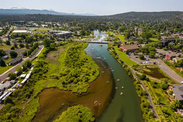 15 Haziran 2025, Bend, Oregon, ABD. İnsanlar, Deschutes Nehri 'nin Eski Değirmen Bölgesi' nden akan bu tembel öğleden sonranın tadını çıkarıyorlar. Drone görünümü.
