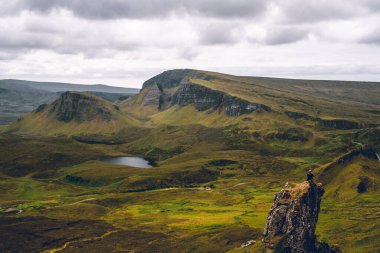 Quiraing, İskoçya 'da büyüleyici bir bakış açısıyla geniş bir manzara gözler önüne seriliyor. Sarp kayalıklar, yeşil yamaçlar ve geniş vadiler dramatik bir tablo oluşturur. Doğanın yüceliğinin hüküm sürdüğü, duyularını büyülediği ve bir u sunduğu bir yer.