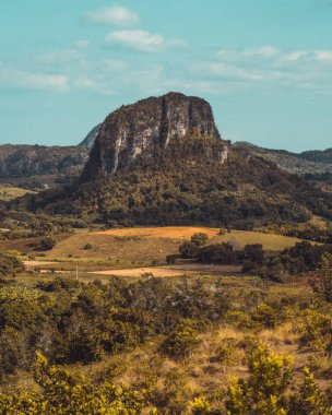 Güneş ışığıyla yıkanan Küba büyüleyici manzarasını gözler önüne seriyor. Yuvarlanan tepeler, yemyeşil tarlalar ve kırsal cazibe Karayip güzelliğinin özünü yansıtan pitoresk bir sahne yaratır.
