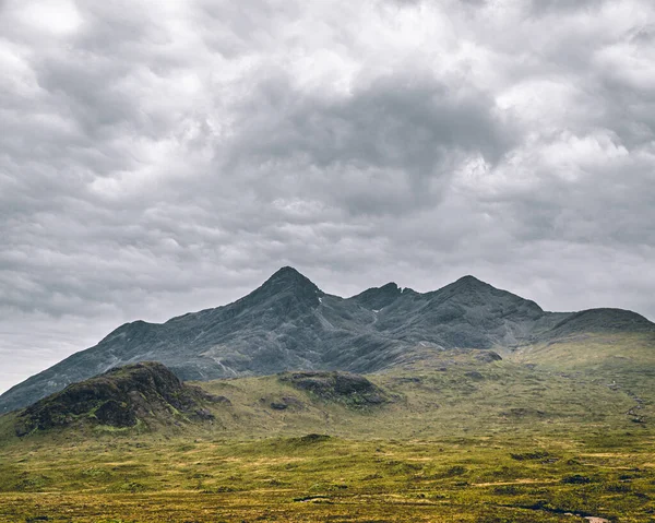 一个全景的远景展开 展现了苏格兰高地雄伟的山峰 在视线所及的地方 崎岖的山顶划破了天空 上面点缀着扫荡的斜坡和薄雾的面纱 这种令人敬畏的景象包罗万象 — 图库照片