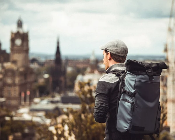 stock image In a lofty viewpoint overlooking Edinburgh, a person strikes a pose, capturing the essence of the vibrant city. Against the backdrop of iconic landmarks and winding streets, they embody a sense of awe and admiration, symbolizing the connection betwee