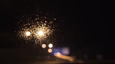 Yağmur damlaları arabanın ön camına damlıyor ve sulu bir senfoni oluşturuyor. Silecekler zarif bir şekilde damlacıkları silip süpürür, doğanın gözyaşlarının yumuşak ritmi arasında berrak bir manzara ortaya çıkarır.