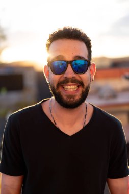 Gözlüklü genç bir adamın portresi: Bir güneş ışığı, kendine güvenen genç bir adamın kendine güvenen bakışını çerçeveler, onun gençlik cazibesini yakalar..