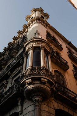 Altın saat, Barcelona 'da bir binanın köşesinde sıcak bir parıltı saçarak mimari detaylarını aydınlatıyor ve büyüleyici bir ışık ve gölge oyunu yaratıyor..