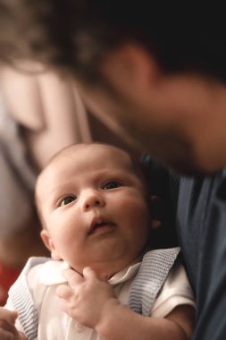Bir bebeğin masum yüzü, babasının sevgi dolu gözlerine bakar ve kırılmaz bir bağ kurar..