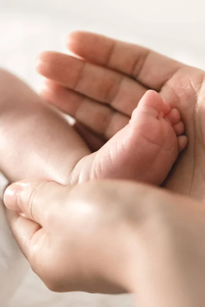 stock image A father's hands cradle the tiny feet of his baby, creating a tender and heartwarming moment of love and connection.