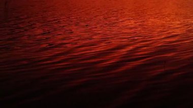 Göl yüzeyine yansıyan güneş ışığı ve turuncu renk.