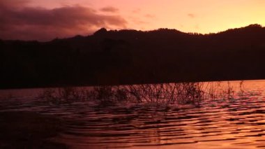 Göl manzarası inanılmaz turuncu renkli gündoğumu altın bulutlu arka plan 