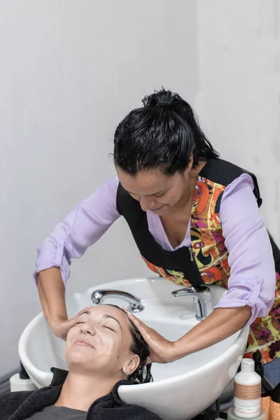 Stock image Hairdresser washing girls hair while she has her eyes closed