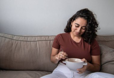 Kıvırcık saçlı kız bir günlük eğitimden sonra kaseden yemek yiyor. Boşluğu kopyala