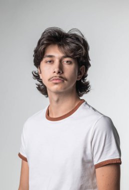 Bıyıklı ve ciddi görünüşlü genç bir çocuğun stüdyo portresi.