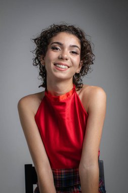 Kıvırcık saçlı kızın stüdyo seansı. Dikey fotoğraf