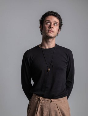 Kıvırcık saçlı çocuğun dikey stüdyo portresi