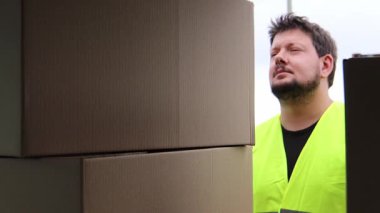 Man checking barcodes on boxes. He is wearing all the safety gear