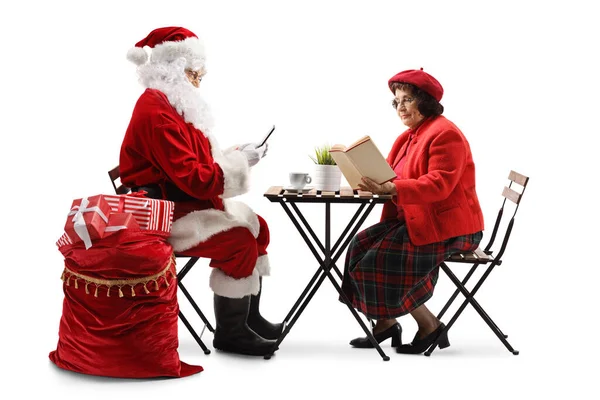 Santa Claus Använder Smartphonr Och Äldre Kvinna Sitter Vid Ett — Stockfoto