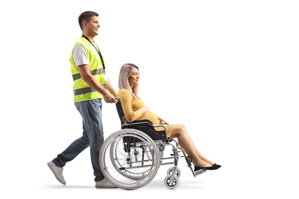 Pełny Profil Pracownika Społecznego Pchającego Ciężarną Kobietę Wózku Inwalidzkim Białym — Zdjęcie stockowe