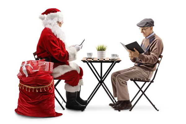 Santa Claus Usando Smartphone Anciano Sentado Una Mesa Leyendo Libro — Foto de Stock