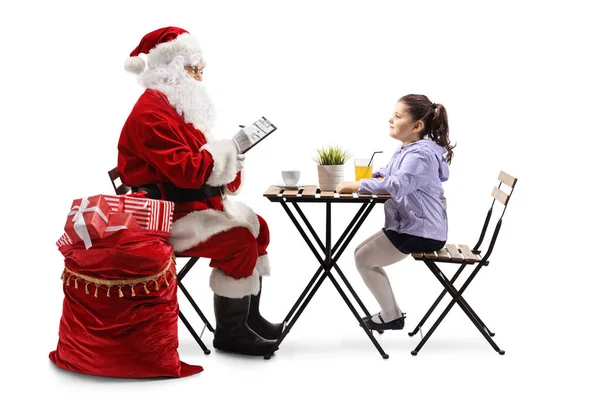 Święty Mikołaj Pisząc Siedząc Przy Stole Małą Dziewczynką Białym Tle — Zdjęcie stockowe