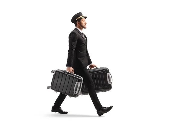 フル長さプロファイルショットのベルボーイ歩行と運ぶ二つのスーツケース隔離された上の白い背景 — ストック写真