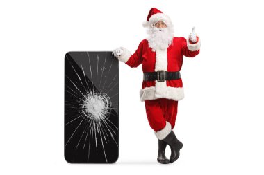Noel Baba, kırık ekranlı bir cep telefonuna yaslanmış ve beyaz arka planda izole edilmiş baş parmaklarını gösteriyor.
