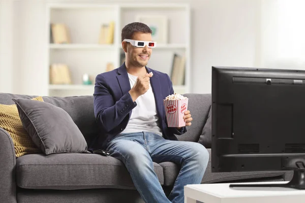 戴著3D眼镜的男人吃爆米花 坐在家里沙发上看电视 — 图库照片