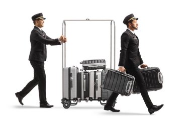 Beyaz arka planda izole edilmiş bir otel bavulunda valiz ve diğer ıvır zıvır taşıyan bellboy.