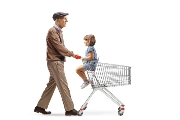 白い背景に隔離されたショッピングカートで子供と歩く高齢者の完全な長さのプロフィールショット — ストック写真