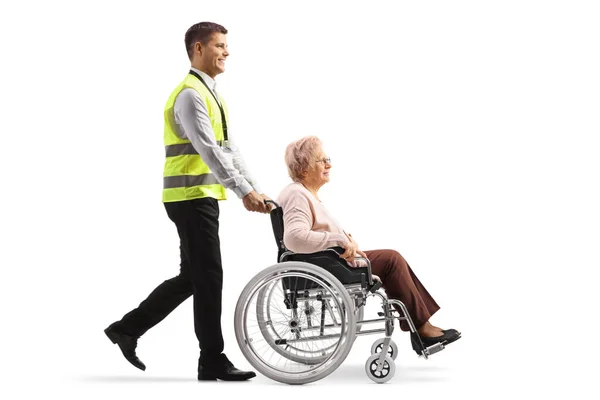 一名机场工作人员推着一名坐在轮椅上 与白人隔离的老年妇女的全景照片 — 图库照片