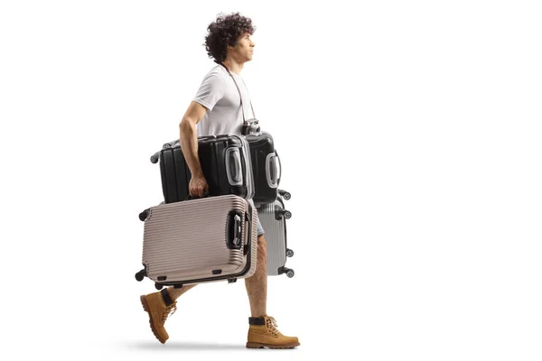 フル長さプロファイルショットの若いです男を持っています重いスーツケースと歩行隔離された白い背景 — ストック写真