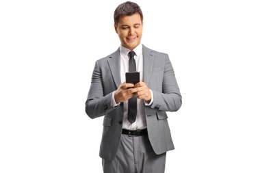 Beyaz arka planda izole edilmiş akıllı telefon kullanan gri takım elbiseli genç profesyonel bir adam.