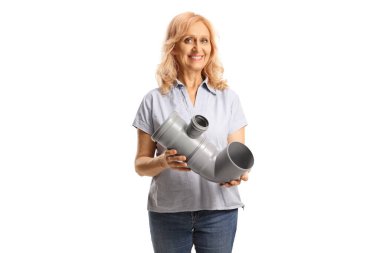 Beyaz arka planda plastik bir su borusu tutan ve gülümseyen bir kadın.