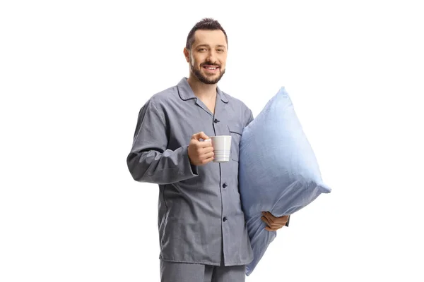 白い背景に孤立した枕とカップを持っているパジャマの若い男 — ストック写真