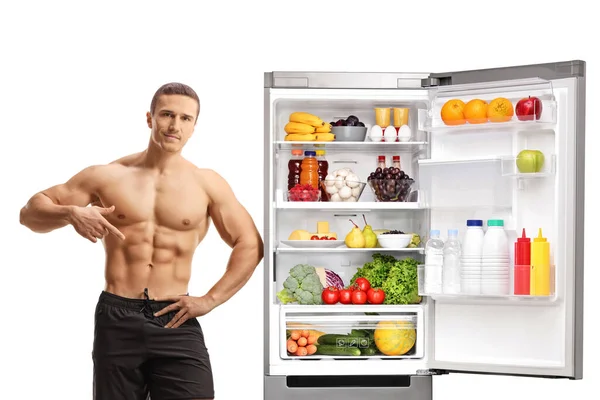 Férfi Mutat Izmait Támaszkodik Hűtőre Egészséges Élelmiszer Elszigetelt Fehér Alapon — Stock Fotó