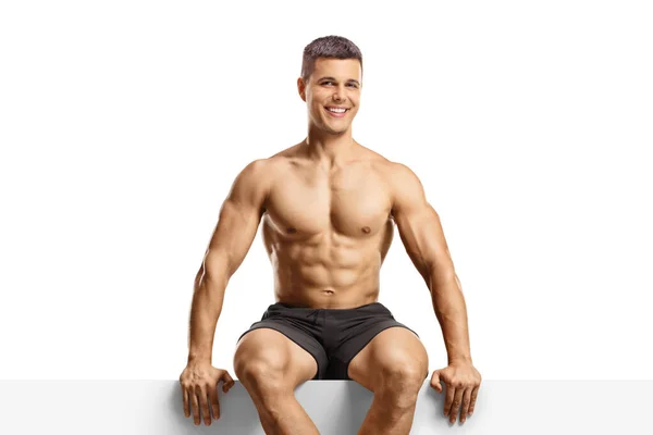 Bodybuilder Sitzt Auf Einem Leeren Panel Isoliert Auf Weißem Hintergrund — Stockfoto