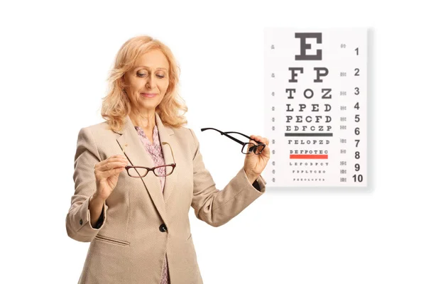 在白色背景下隔离的视力测试前 女性将两副视力眼镜进行对比 — 图库照片