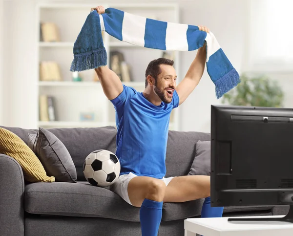 Veselý Muž Sportovním Dresu Jásající Šálou Sledující Fotbal Doma Televizi — Stock fotografie