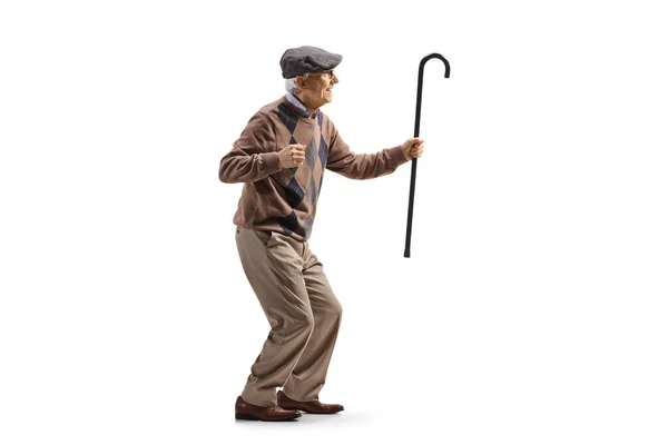 一个快乐的老年男子手握一根白色背景手杖跳舞的全景照片 — 图库照片
