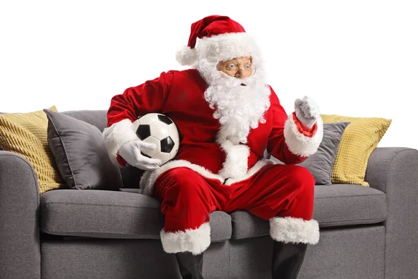 Санта Клаус Аплодирует Держит Футбол Сидит Диване Белом Фоне — стоковое фото