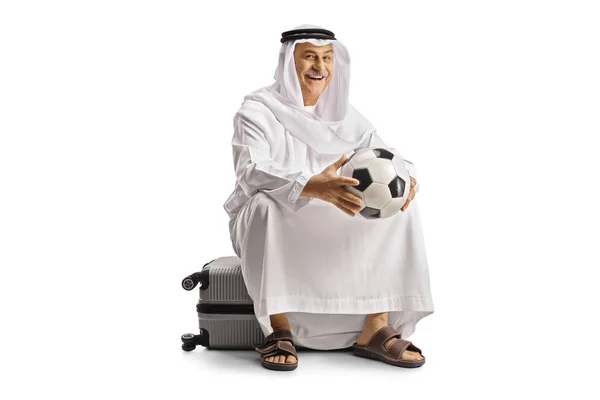 Усміхнений Зрілий Арабський Чоловік Етнічному Одязі Сидить Валізі Тримає Футбол — стокове фото