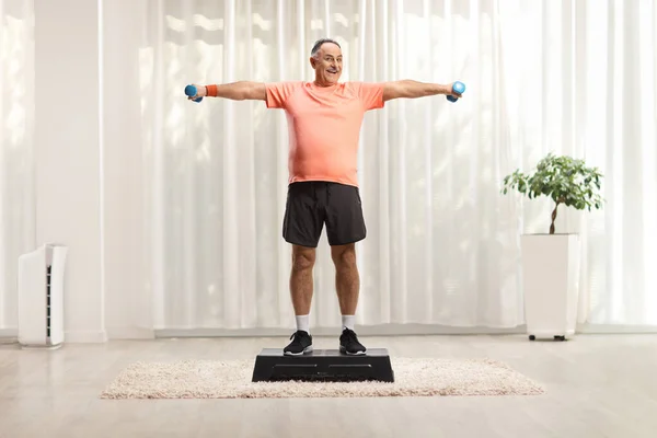 成年男子在室内进行步法有氧运动和举重的全长肖像 — 图库照片