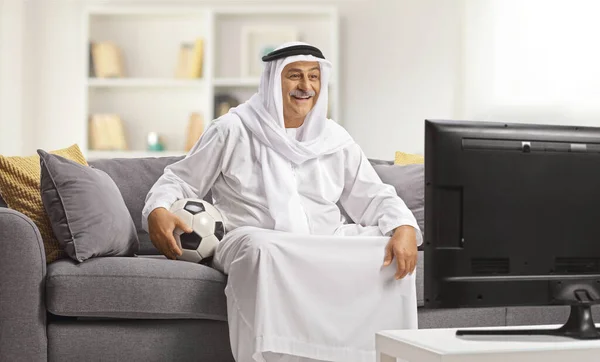 Homem Árabe Manto Tradicional Segurando Uma Bola Assistindo Futebol Casa — Fotografia de Stock