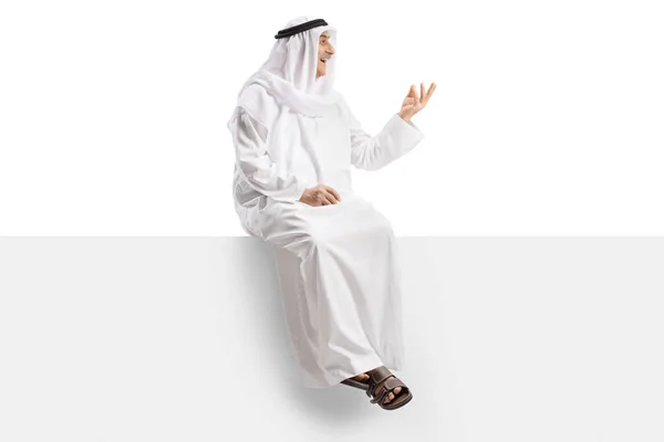 白い背景に隔離された手でジェスチャーと空白のパネルに座っている民族のローブのアラブ人 — ストック写真