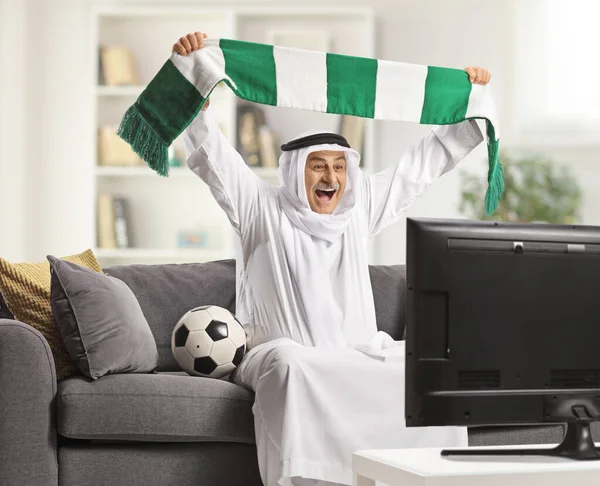 Excitado Árabe Homem Robe Tradicional Segurando Lenço Assistir Futebol Casa — Fotografia de Stock