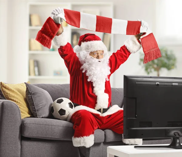 Heyecanlı Noel Baba Futbol Izleyip Evde Eşarpla Tezahürat Yapıyor — Stok fotoğraf