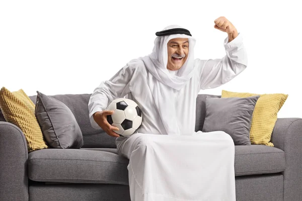 Зрілий Арабський Чоловік Халаті Тримає Футбол Вітає Сидіння Дивані Ізольовано — стокове фото