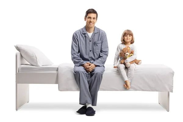 Πατέρας Και Κόρη Πιτζάμες Κάθονται Ένα Κρεβάτι Απομονωμένοι Λευκό Φόντο — Φωτογραφία Αρχείου