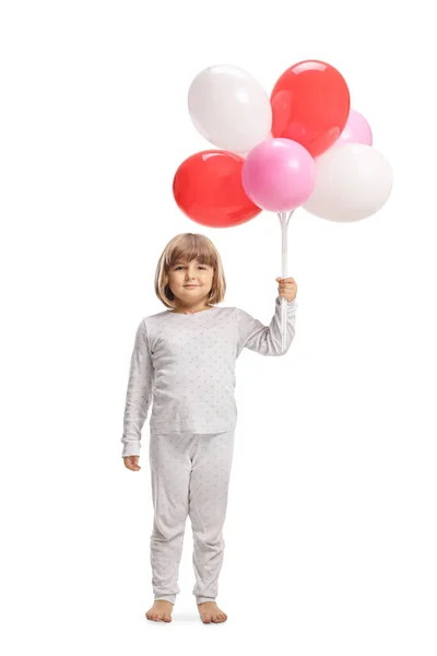 穿着睡衣的可爱小女孩拿着用白色背景隔开的气球 — 图库照片