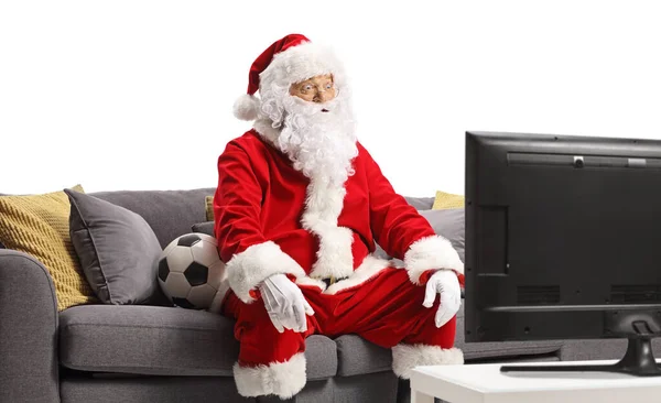 Zaskoczony Mikołaj Siedzi Kanapie Ogląda Piłkę Nożną Telewizji Odizolowany Białym — Zdjęcie stockowe