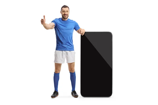 Pełna Długość Portret Piłkarza Stojącego Obok Dużego Smartfona Pokazującego Kciuki — Zdjęcie stockowe